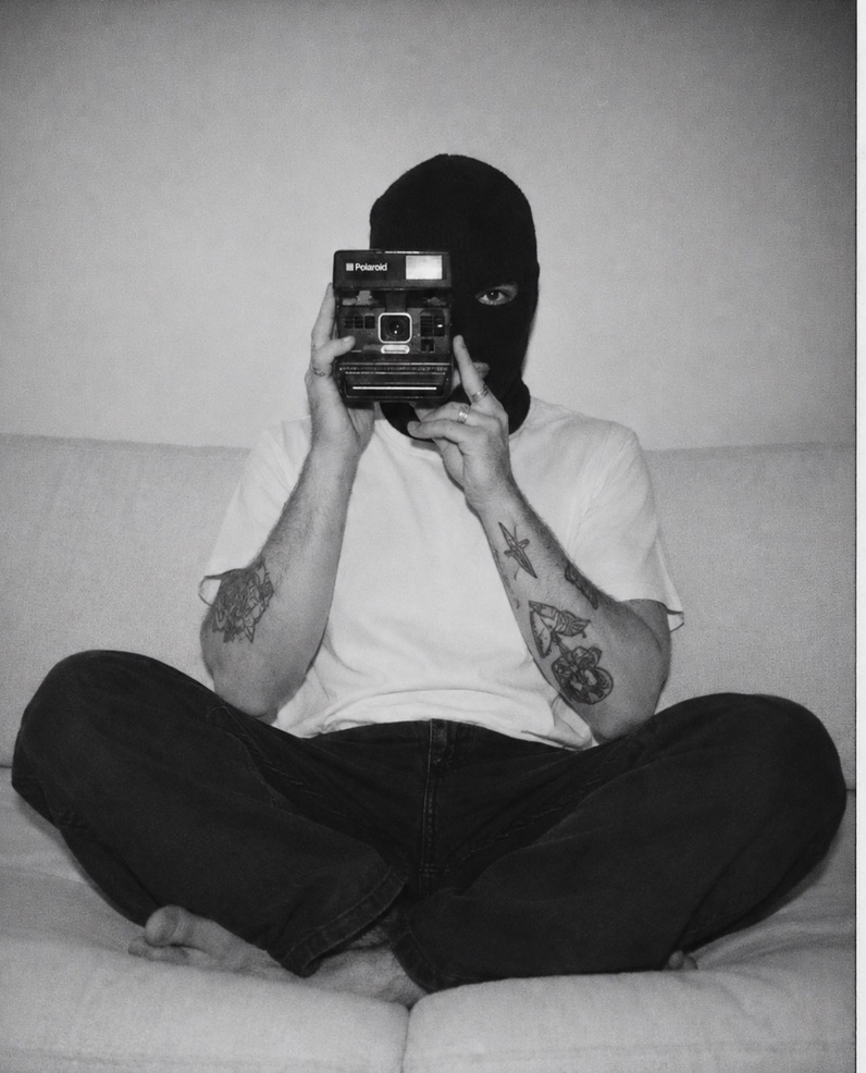 Seated portrait holding a Polaroid camera