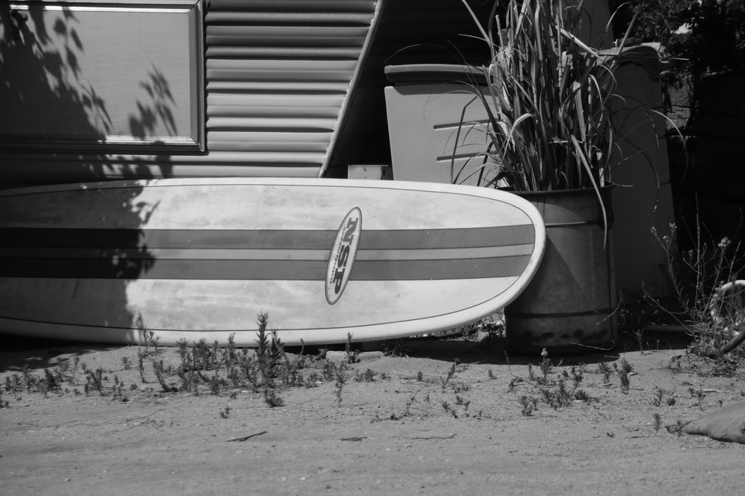 Surfboard resting in hard California light